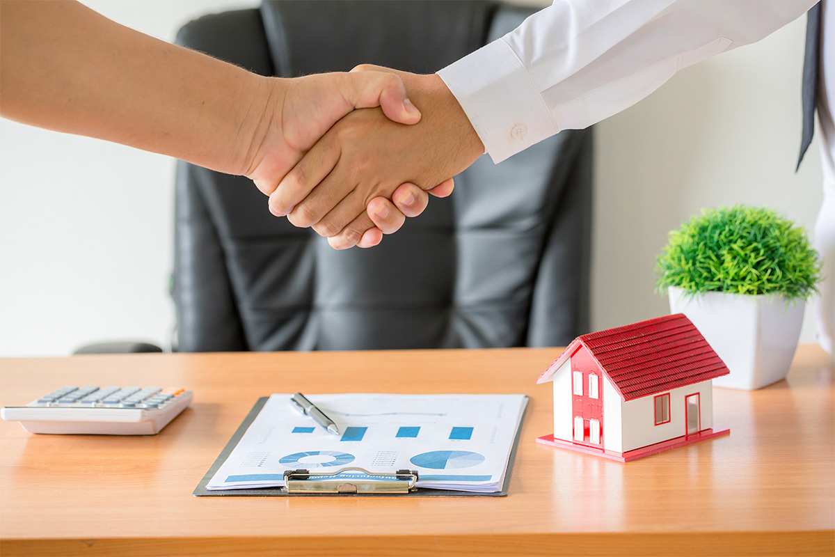 Asesores inmobiliarios revisando documentos con clientes